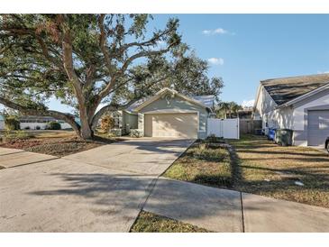 House exterior, featuring a light green color, metal roof, and a large tree in the front yard at 510 45Th E St, Bradenton, FL 34208