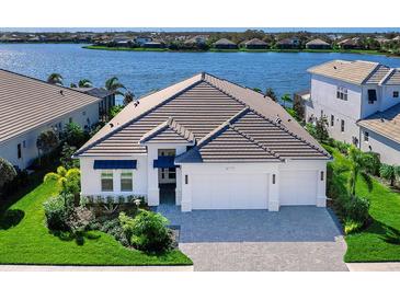 Luxury home with lake view, two-car garage, and landscaped yard at 7917 Mainsail Ln, Sarasota, FL 34240