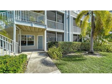 Condo exterior showcasing a walkway, second story balcony, lush landscaping, and a view of the building facade at 850 S Tamiami Trl # 408, Sarasota, FL 34236