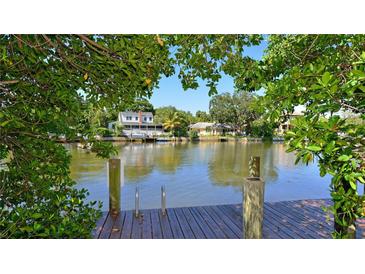 Waterfront property featuring a dock with views of neighboring houses along the canal at 850 S Tamiami Trl # 408, Sarasota, FL 34236