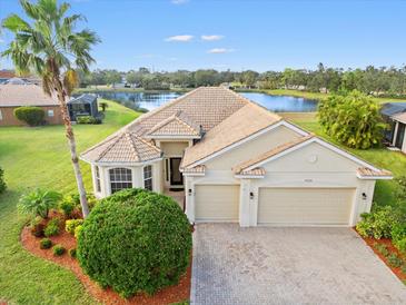 Single-story home with tile roof, two-car garage, and landscaped lawn at 9109 Winter Harbour Way, Bradenton, FL 34212