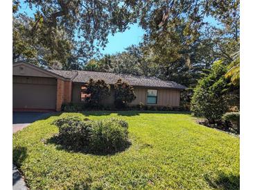 Brick ranch home with a well-maintained lawn and mature trees at 1507 Water Oak Way S, Bradenton, FL 34209