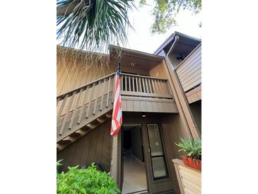 Exterior view of condo entrance with stairs and American flag at 1677 Brookhouse Cir # 125, Sarasota, FL 34231