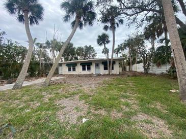 Ranch-style home with palm trees and a grassy yard at 175 Island Cir, Sarasota, FL 34242