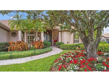 Landscaped front yard with mature trees and colorful flowers at 2611 Little Country Rd, Parrish, FL 34219