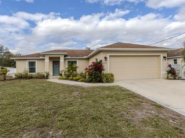 Tan house with brown roof, landscaping, and a two-car garage at 4352 Adelaide Ave, North Port, FL 34288