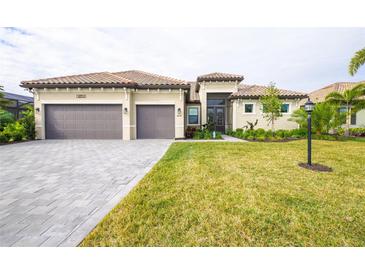 Two-story house with three car garage, paver driveway and landscaping at 4814 Sparkling Sea Ln, Lakewood Ranch, FL 34211