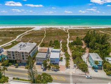 Aerial view of beachfront property with ocean access, showing multiple buildings and lush landscaping at 600/602 Beach Rd # 1 & 2, Sarasota, FL 34242