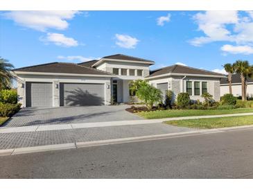 Stunning single-story home with a three-car garage, stone accents and beautiful landscaping at 9020 Artisan Way, Sarasota, FL 34240