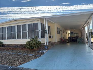 Yellow mobile home with carport and covered patio at 2107 Palma Sola Blvd # 27, Bradenton, FL 34209