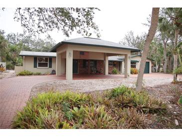 Single-story home with brick paver driveway and carport at 5353 Shadow Lawn Dr, Sarasota, FL 34242