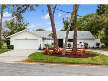 White single-story home with a two-car garage and landscaped yard at 5575 Beneva Woods Cir, Sarasota, FL 34233