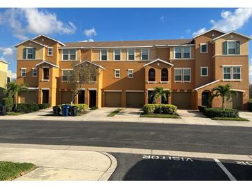 Tan three-story townhouses with attached garages and landscaping at 8908 White Sage Loop, Lakewood Ranch, FL 34202
