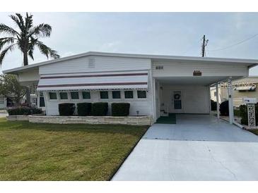 Single-wide manufactured home with carport and landscaping at 1111 42Nd E Ave, Ellenton, FL 34222