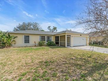 Charming single-story home with a well-maintained lawn, a screened porch and an attached two car garage at 1382 Ronald St, North Port, FL 34286