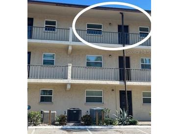 Exterior view of condo building showcasing balcony and parking at 2220 Stickney Point Rd # 537, Sarasota, FL 34231