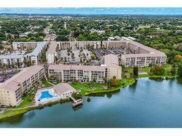Aerial view of a condo community with pool, lake, and parking at 3544 Lake Bayshore Dr # K123, Bradenton, FL 34205