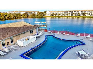 Community pool with lake view; deck furniture and waterfront access at 3751 Lake Bayshore Dr # H304, Bradenton, FL 34205