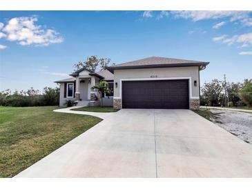 Single-story home with attached garage and landscaped lawn at 4310 Zenith Rd, Venice, FL 34293