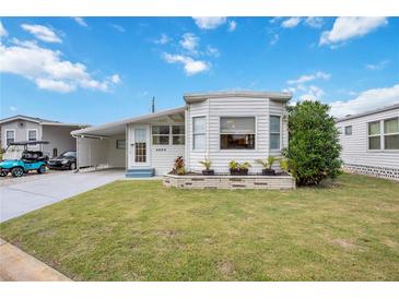 White single-wide mobile home with carport and landscaped lawn at 4953 Sea Island Ave, Sarasota, FL 34234