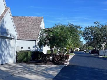 Exterior view of a light blue condo building with palm trees and landscaping at 6707 Stone River Rd # 203, Bradenton, FL 34203