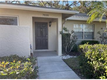 Inviting condo exterior with landscaped walkway and entrance at 7030 W Country Club N Dr # 128, Sarasota, FL 34243