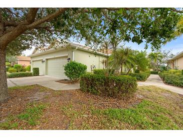 House exterior showcasing a two-car garage and nicely landscaped grounds at 209 Fontanelle Cir, Venice, FL 34292