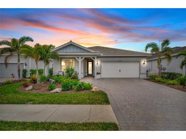 Two-story home with landscaped yard and brick driveway at 26017 Seastone Dr, Englewood, FL 34223