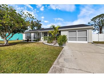 Ranch-style home with landscaped lawn and driveway at 6756 Electra Ave, North Port, FL 34287