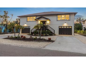 Two-story home with two-car garage and landscaped yard at 127 Crescent Dr, Anna Maria, FL 34216