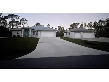 Two-story house with attached garage and detached garage, long driveway at 142 Solana St, North Port, FL 34287