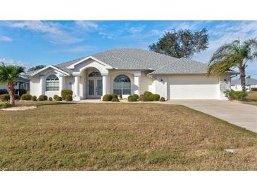 Single story home with a grey roof, white exterior, and a neatly landscaped yard at 2053 Rio De Janeiro Ave, Punta Gorda, FL 33983