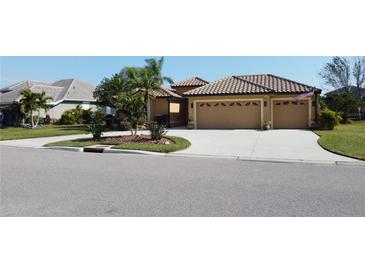 Tan three-car garage house with tile roof, manicured lawn, and palm trees at 3001 Seasons Blvd, Sarasota, FL 34240