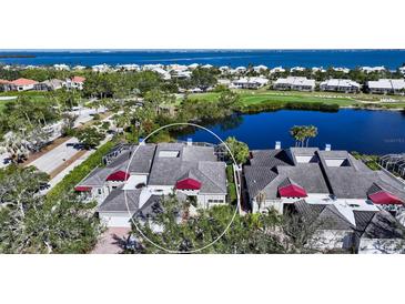 Aerial view of a beautiful home community with waterfront access and lush landscaping at 3465 Winding Oaks Dr # 33, Longboat Key, FL 34228