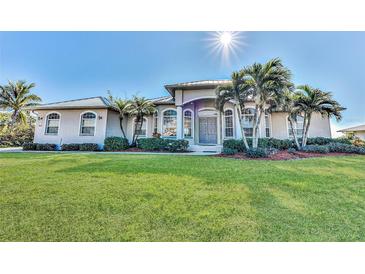 Beautiful waterfront home with lush landscaping and a metal roof at 3662 Peace River Dr, Punta Gorda, FL 33983