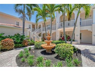 Exterior view of condo building with fountain and lush landscaping at 4264 Central Sarasota Pkwy # 122, Sarasota, FL 34238