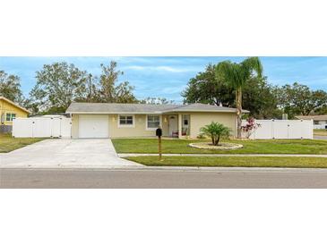 Cute ranch home with a fenced yard, driveway, and mature landscaping at 5425 Skyline Pl, Sarasota, FL 34232