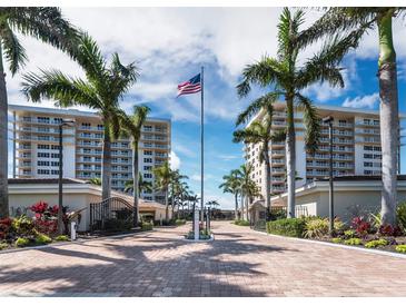 Gated community entrance with palm trees and two high-rise buildings in background at 603 Longboat Club Rd # 1102N, Longboat Key, FL 34228