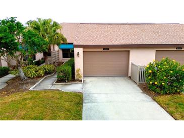 Attractive villa with 2-car garage, landscaping, and a paved driveway at 6085 Clubside Dr # 7682, Sarasota, FL 34243