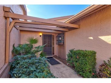 Inviting entryway with covered walkway, lush landscaping, and a charming door at 6131 Heritage Ln # 6131, Bradenton, FL 34209
