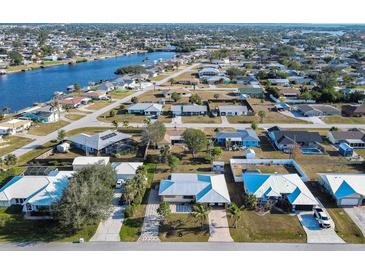 Aerial view of residential neighborhood, showcasing homes and waterways at 817 Linnaen Nw Ter, Port Charlotte, FL 33948