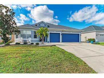 Two-story house with blue garage doors and well-manicured lawn at 12219 23Rd E St, Parrish, FL 34219