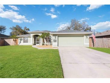 Charming single-story home with a well-manicured lawn, two-car garage, and inviting front entrance at 1817 New London St, North Port, FL 34288