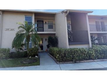 Exterior view of condo building with landscaping and walkway at 2599 Woodgate Ln # K7, Sarasota, FL 34231