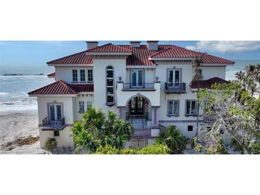 Beachfront home with red tile roof, balcony, and ornate entryway at 3625 Casey Key Rd, Nokomis, FL 34275