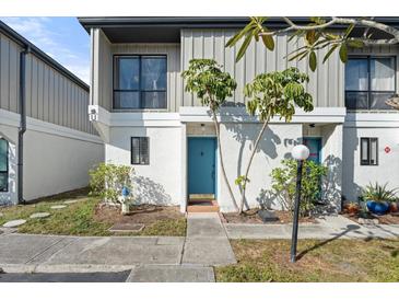 Updated condo exterior with a teal door and well-manicured landscaping at 4001 Beneva Rd # 208, Sarasota, FL 34233