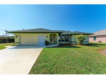 Single-story house with green exterior, attached garage, and well-maintained lawn at 5 Pinehurst Ct, Rotonda West, FL 33947