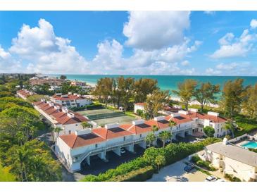 Aerial view of condo community near beach, featuring tennis courts and pool at 5055 Gulf Of Mexico Dr # 424, Longboat Key, FL 34228