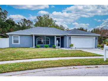 Newly renovated one-story home with gray exterior, landscaped lawn, and attached garage at 5117 19Th E Ln, Bradenton, FL 34203