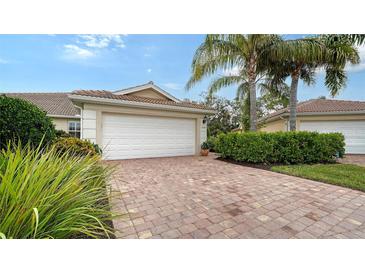 Well-maintained house with a white garage door and a brick driveway at 5890 Guarino Dr, Sarasota, FL 34238